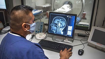Caregiver looking at a scan on a computer of a patient's head