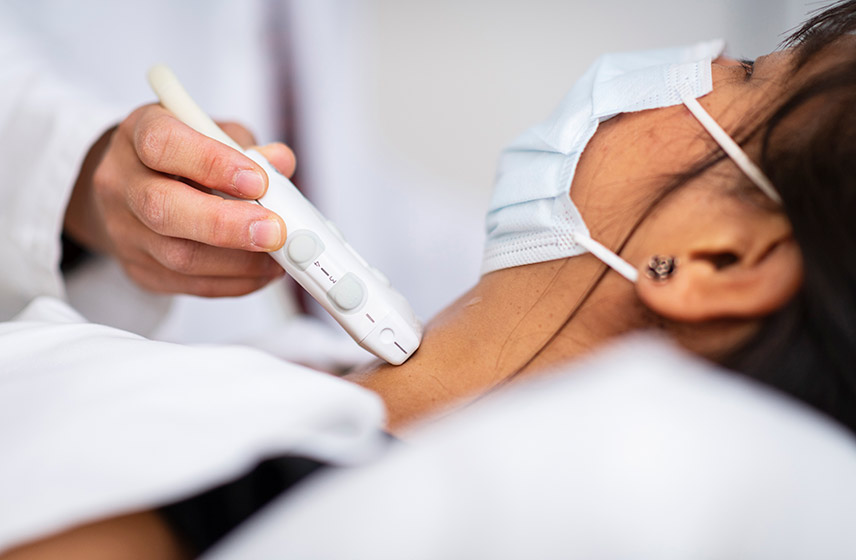 Cleveland Clinic caregiver performing an ultrasound on a patients neck.
