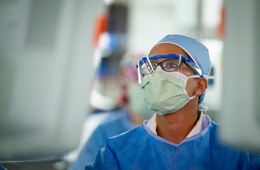 Doctor wearing protective personal equipment while performing a surgical procedure.