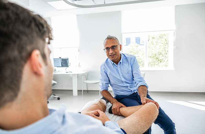 Health professional examining a patient's knee.