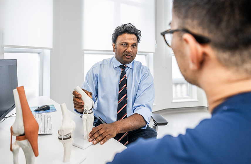 Knee specialist Sam Rajaratnam FRCS consulting with a patient